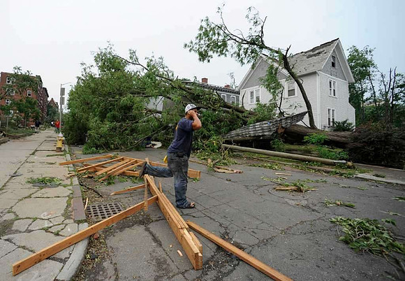 A man talks on his phone near storm damage after a reported tornado struck downtown Springfield, Mass