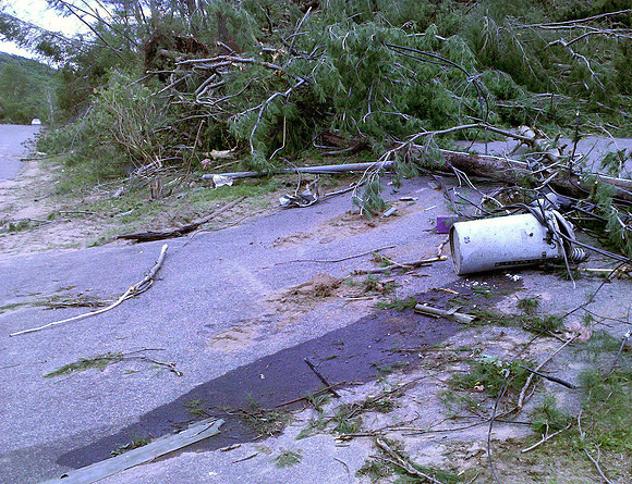 Damaged electrical transformer on the ground and leaking oil.