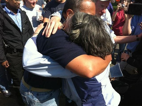 A woman sobs as Gov. Deval Patrick gives her a hug