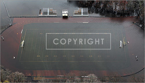 A football field is flooded by the Sudbury River reservoir dam in Framingham.