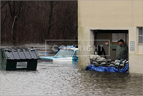 A man at Cycle King gestured to his flooded facility as the Pawtuxett River flooded on Tuesday in Warwick, R.I.