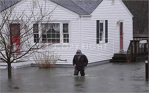 A Cranston resident waded through a flooded front yard.