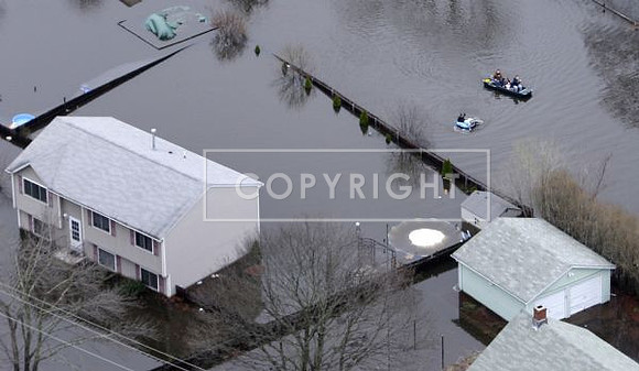 A group of people float through backyards of a neighborhood in West Warwick, R.I