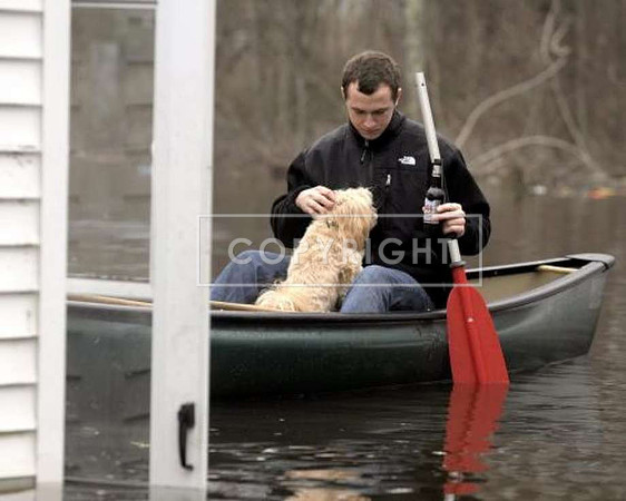 Levi Hill of Groton, Conn., a diver in the U.S. Navy, navigates his canoe to the back door ofhis friend's flooded home, in Westerly, R.I.,