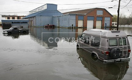 The floodwaters from the Pawtuxet River in West Warwick, R.I., recede to reveal vehicles that were trapped