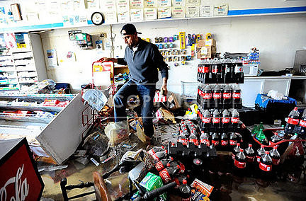 Hicham Ghamrawi, of Cranston, originally of Lebanon, on Thursday surveys the damage flooding caused to his convenience store in Cranston.