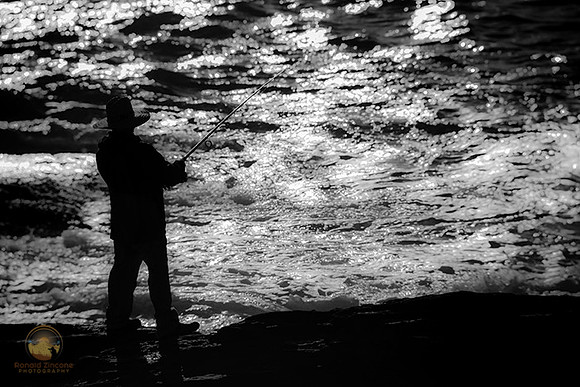 Fisherman in sihouette at Beavertail, RI  copyright ronaldzinconephotography