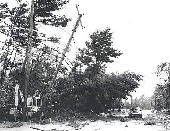 A truck darts through downed trees and power lines on Middle Road in Acushnet